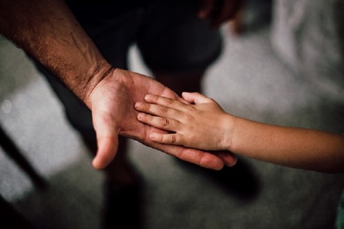 Child's hand on a parent's hand