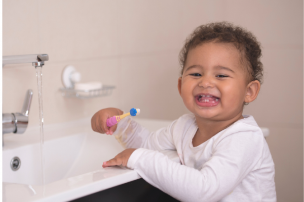 Happy toddler brushing her teeth