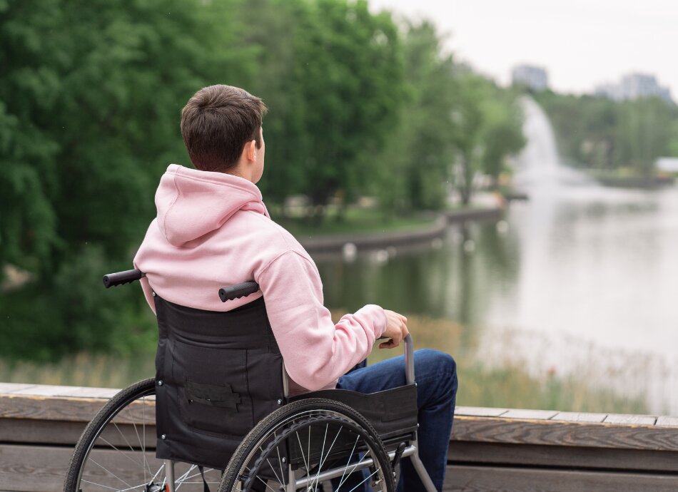 Boy in wheelchair looking out at river