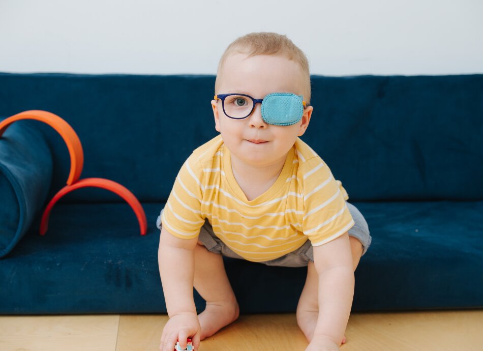 Small child with glasses and eye patch on his left lens