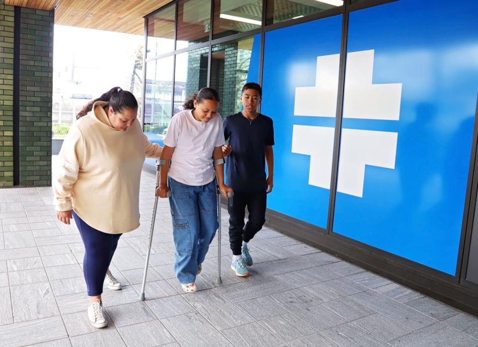 Girl on crutches accompanied to medical centre by mother and brother