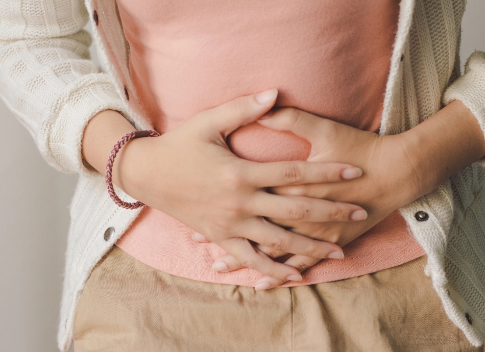 Woman's hands on sore tummy 