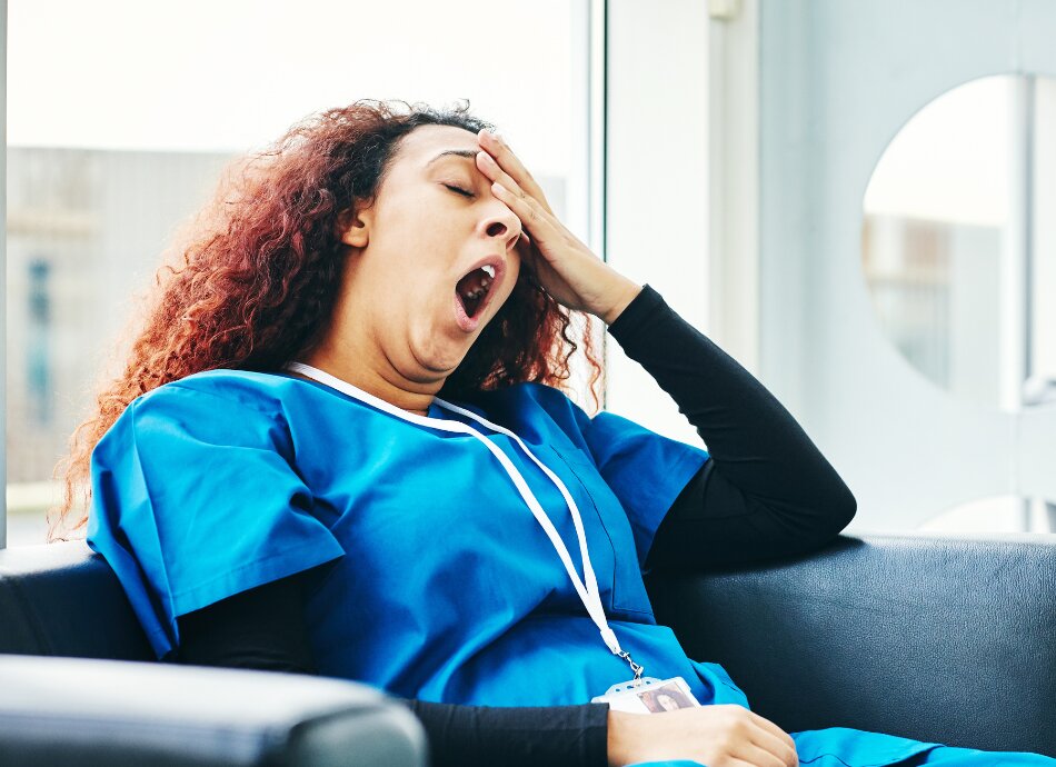 Exhausted yawning female nurse in chair