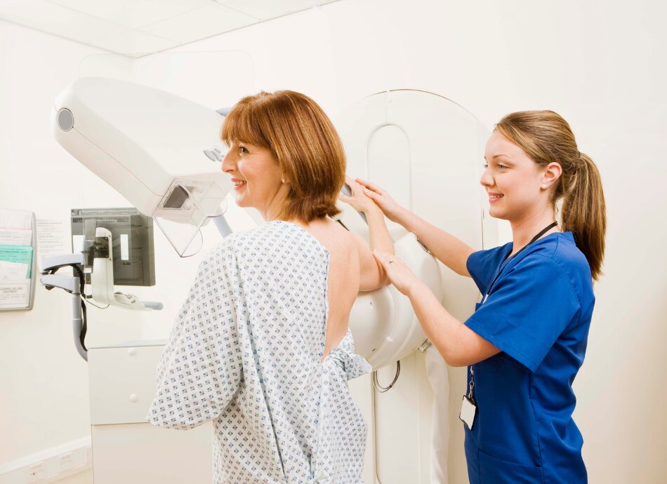 Woman has mammogram guided by technician