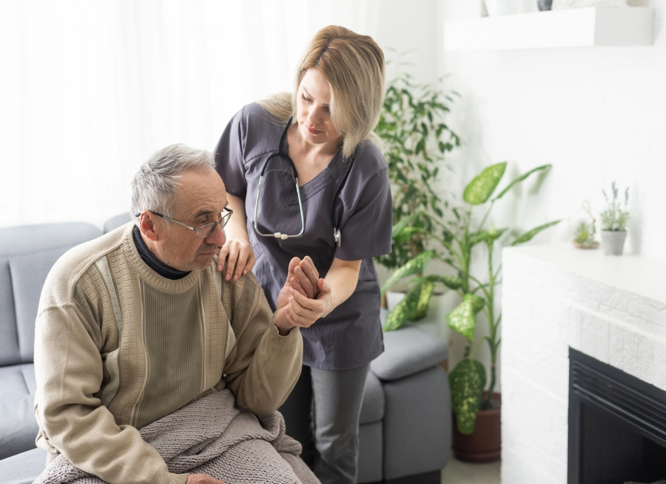 Nurse visiting older man at home 