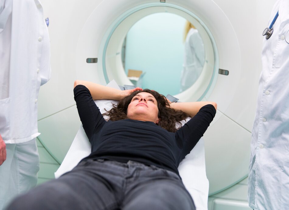 Woman lying on bench about to have PET scan