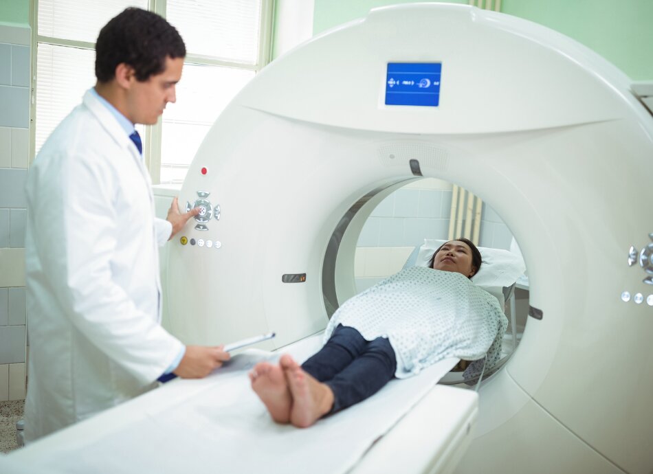 Patient goes into CT scanner guided by healthcare professional