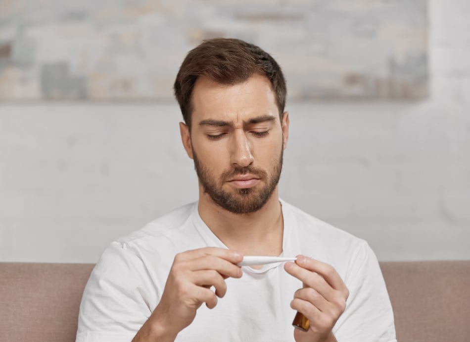 Man looking at digital thermometer 