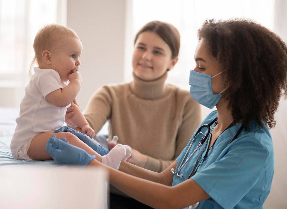 Mother watches while nurse gives baby a vaccination