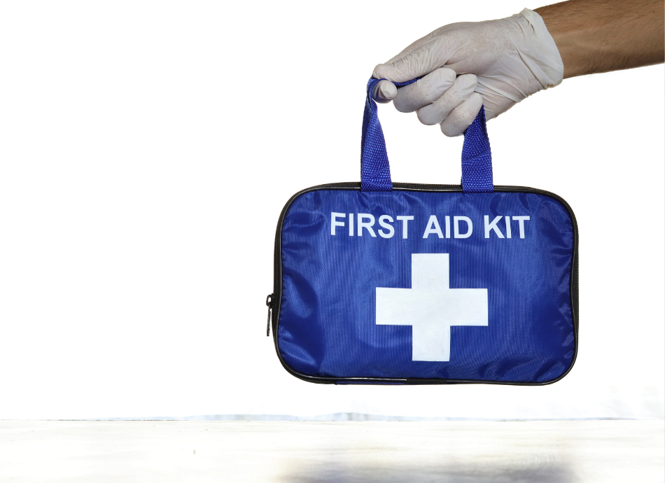 Gloved hand holds first aid kit 