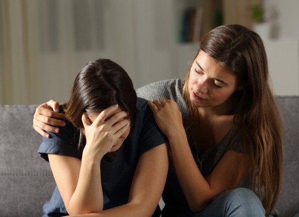 Young woman supporting her upset friend