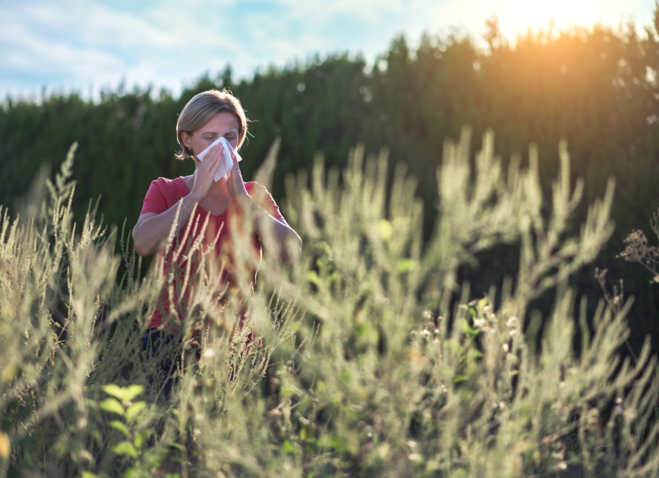 Woman sneezing outside grass allergy 