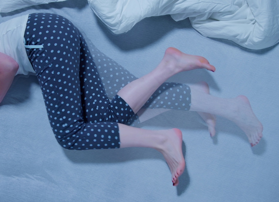 Person in bed with restless legs