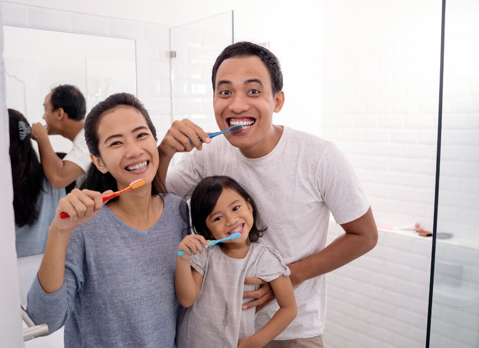 Family brushing their teeth together 