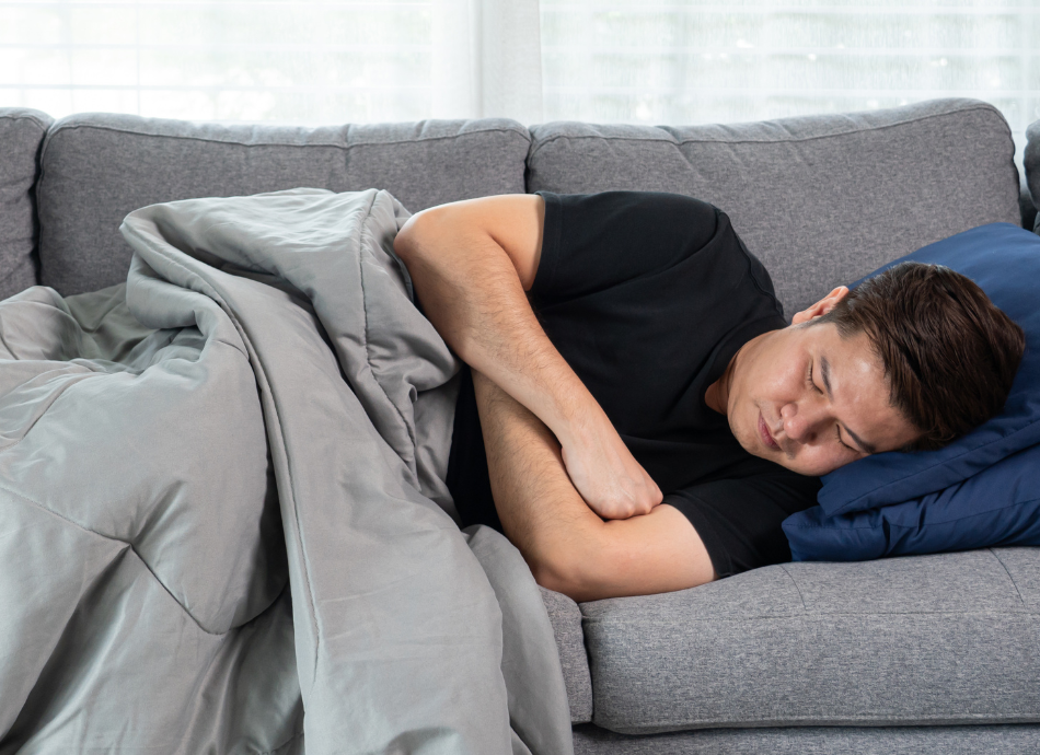 Man sleeping on couch with blanket