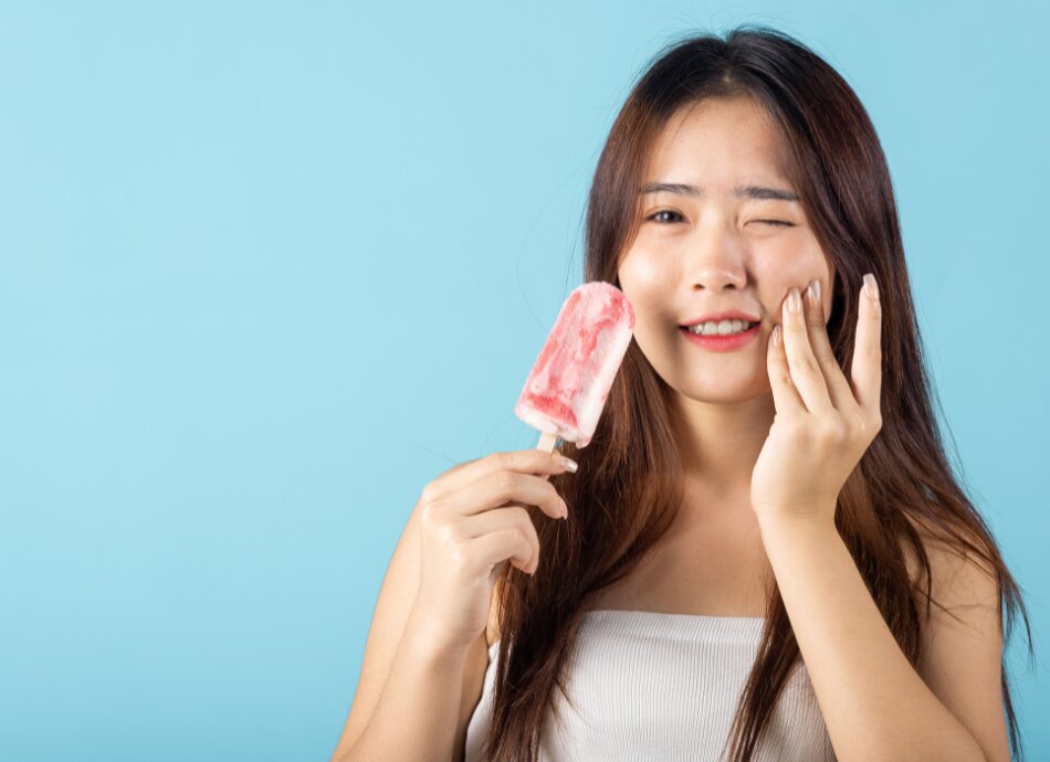 Woman has sensitive teeth when eating iceblock