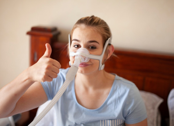 Young woman wearing CPAP mask