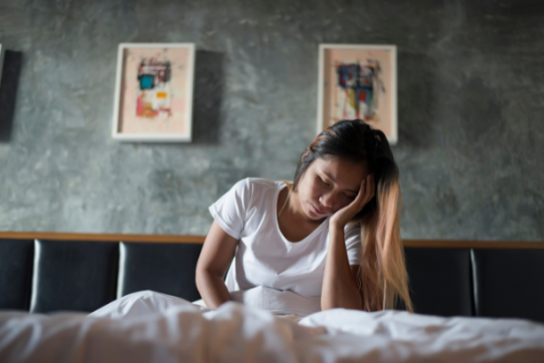 Woman having sleeping problems sitting up in bed