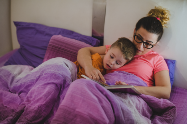 Mum reading to son in bed
