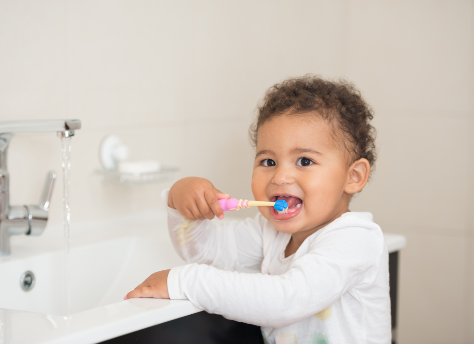 Cute girl toddler brushing her teeth at the sink