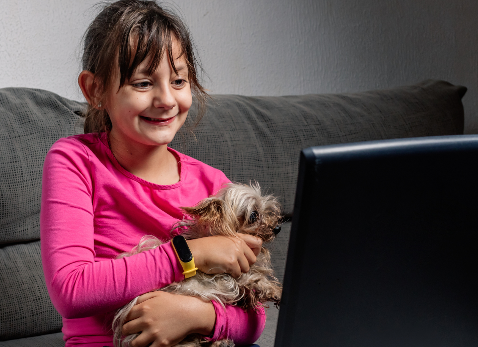 Girl holds puppy while chatting online 