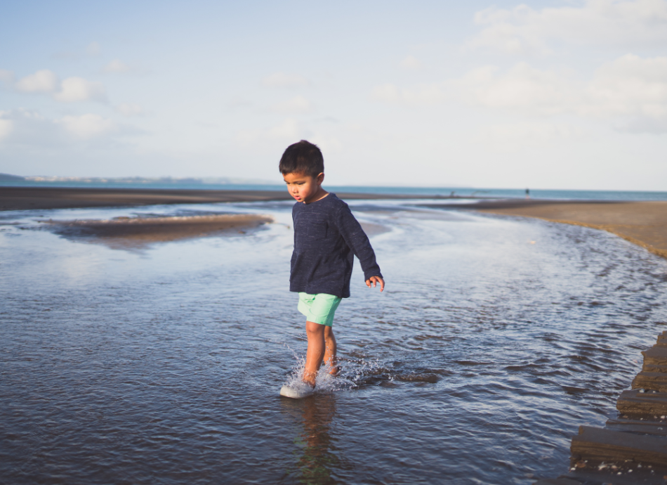 Small boy walking through the water Auckland 
