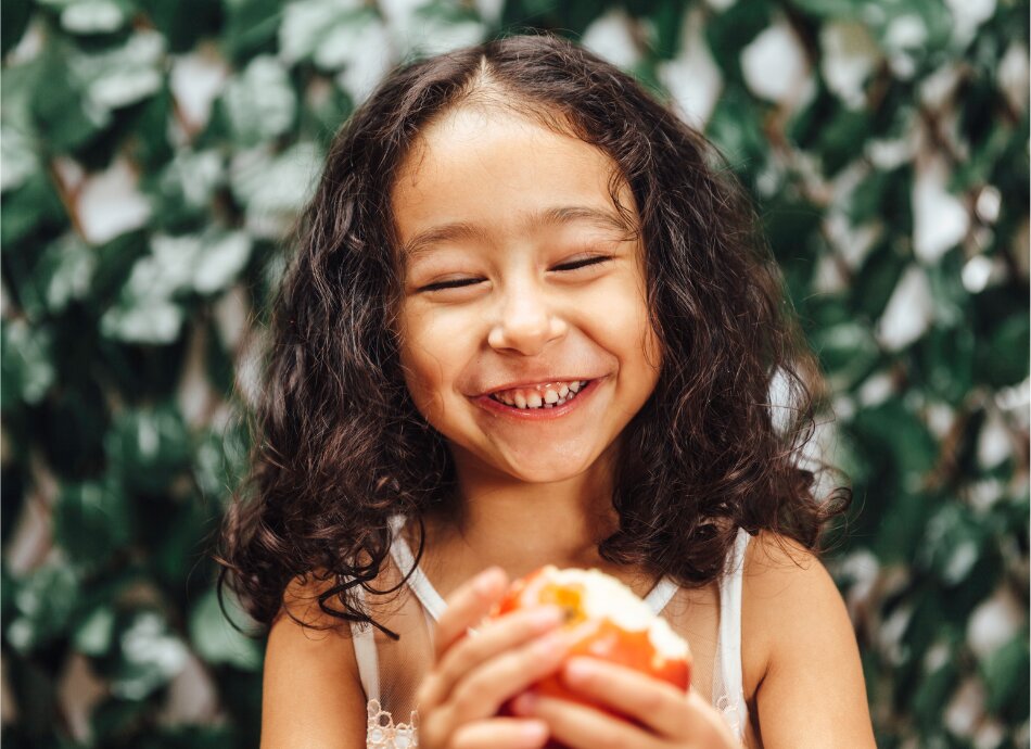 Smiling girl with half-eaten apple