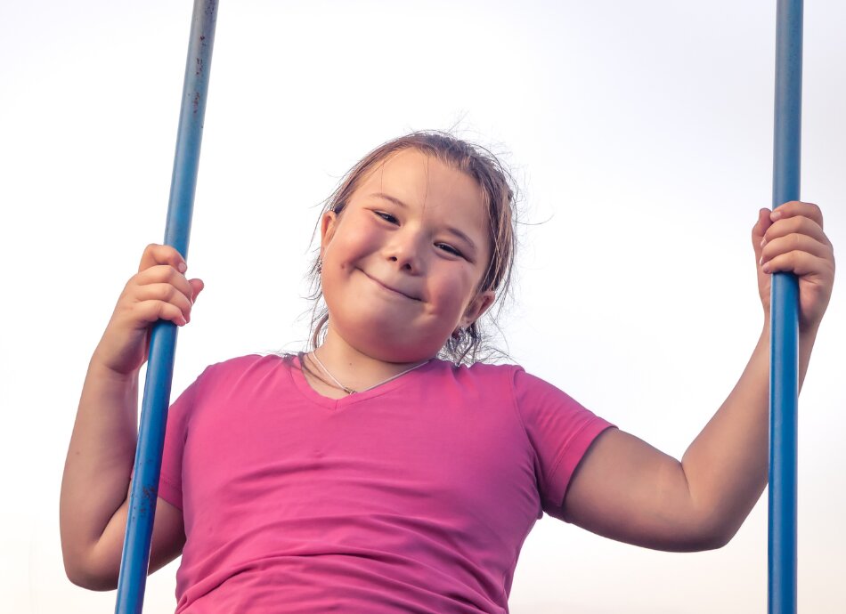 Smiling larger girl on a swing