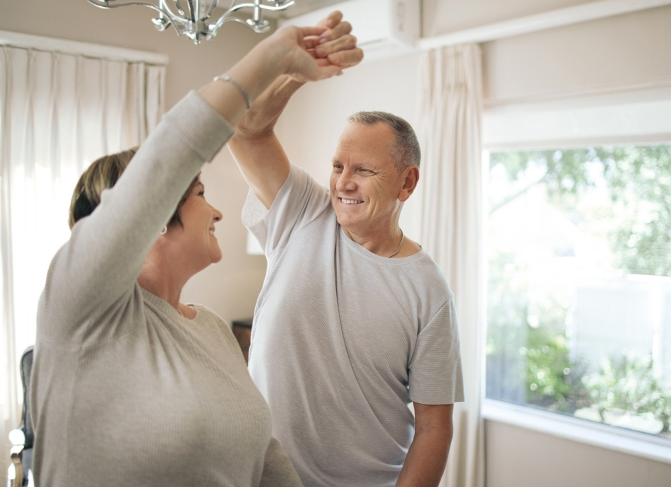 Couple dancing inside and smiling 