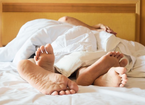 Couple with entwined feet in bed