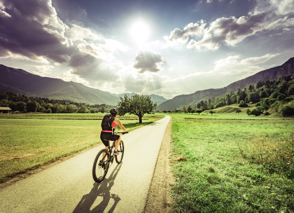Cyclist rides down a sunny country road