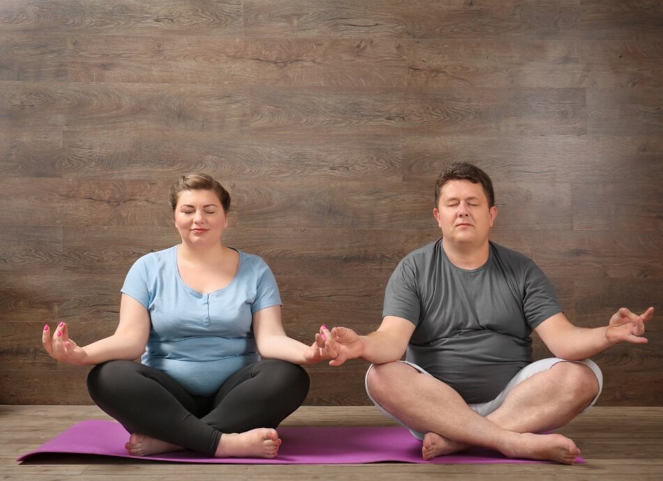 2 larger people crosslegged at yoga