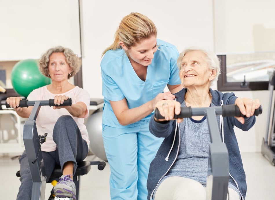 Older woman on exercycle with healthcare provider 