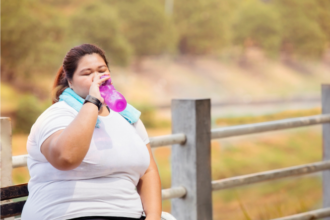Woman drinking from water bottle while exercising