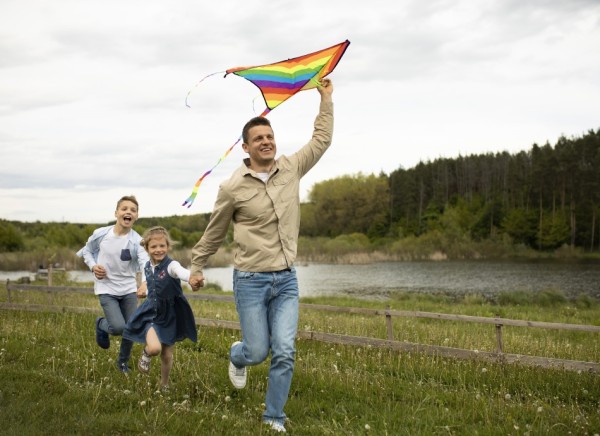 Father and children running with kite