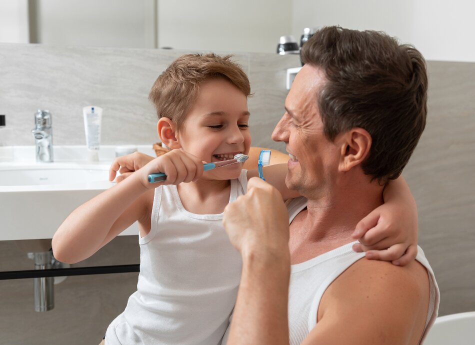 Father and son brushing teeth canva 950x690