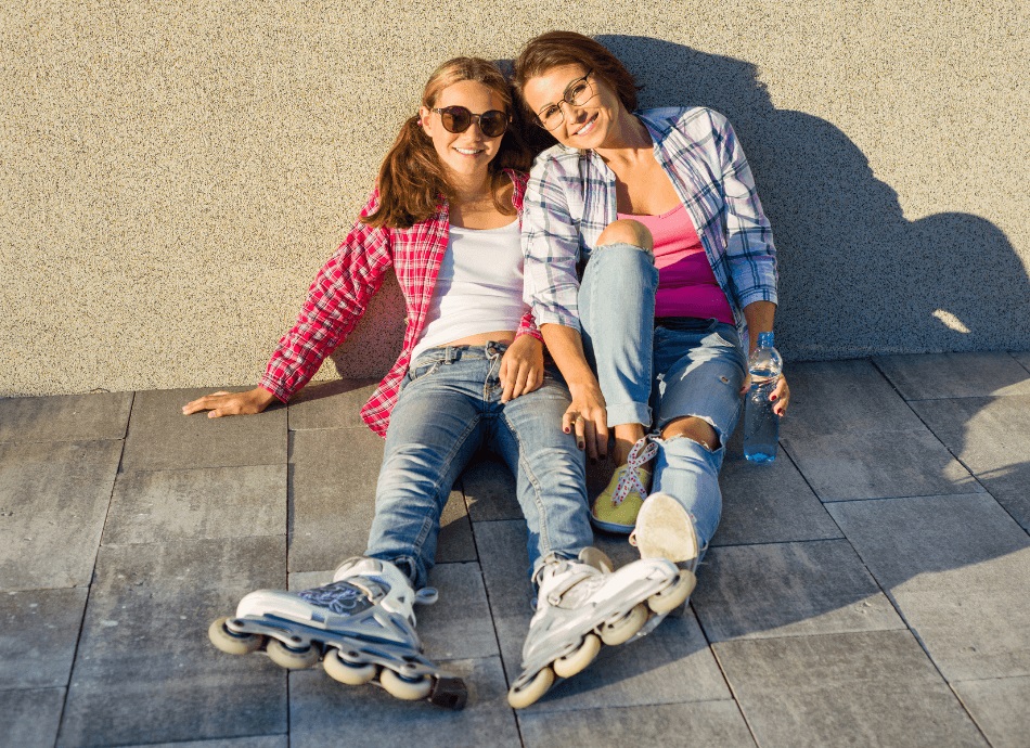Happy mum and daughter resting during roller blading
