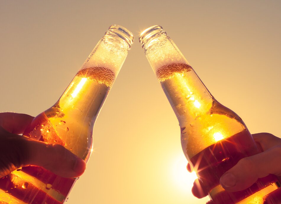 Beer bottles against sunny backdrop 