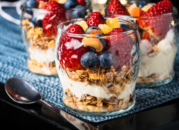 Breakfast of muesli, colourful fruit and yoghurt