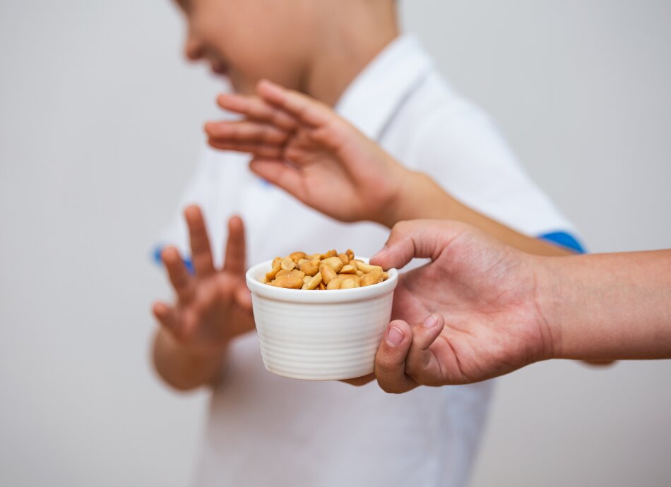 Boy with allergy saying no to peanuts being offered