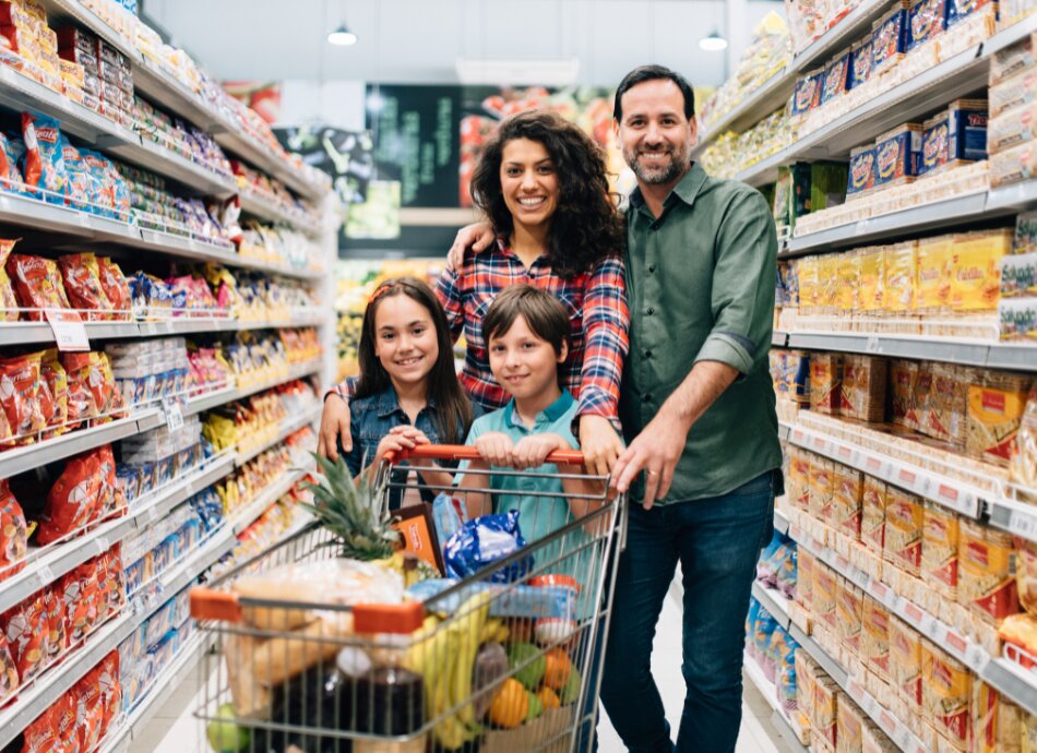 Family of 4 grocery shopping in supermarket aisle