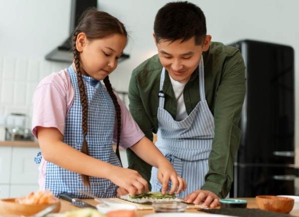 Father and daughter preparing food together