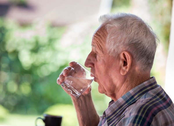 Older man drinking a glass of water