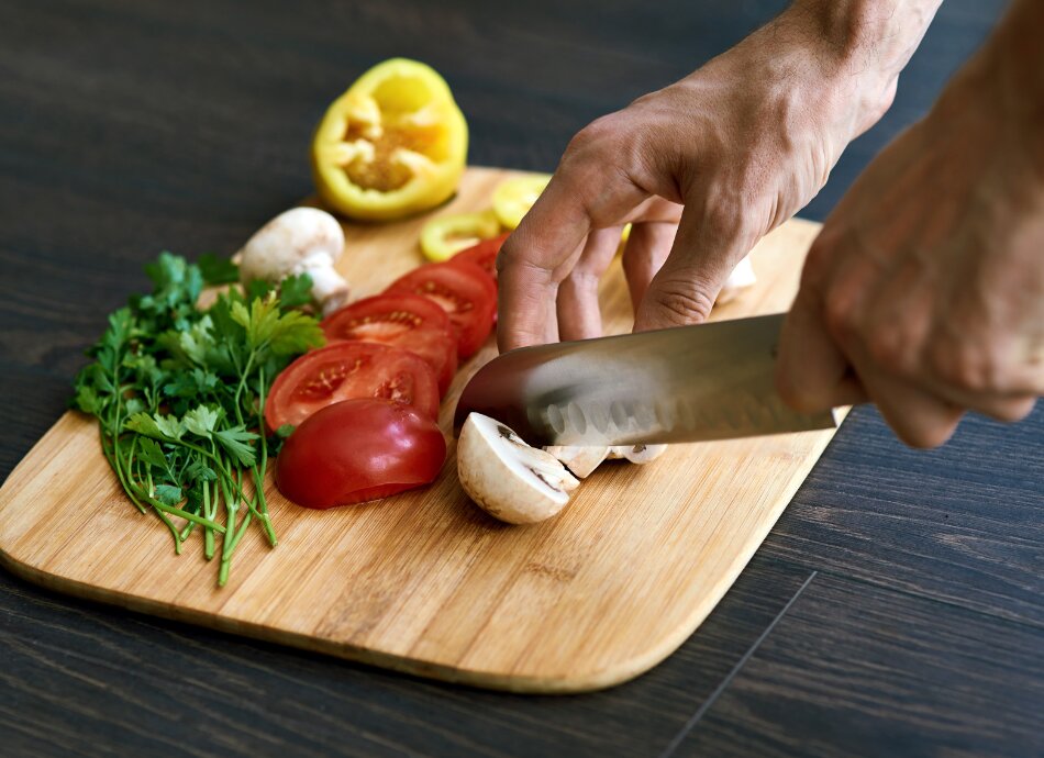 Person chopping vegetables on a wooden board