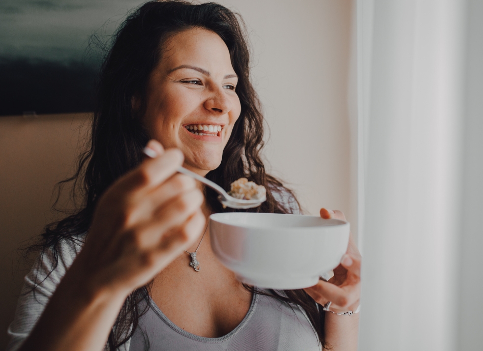 Smiling woman eating cereal 