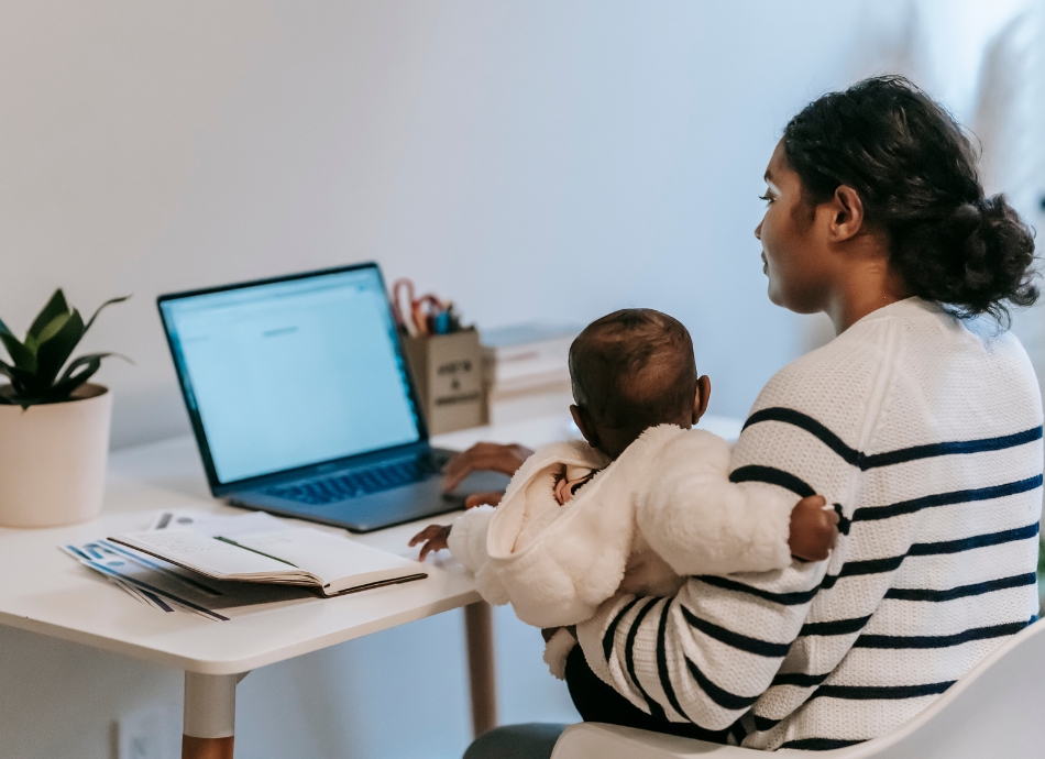 Young mother holding baby working from home