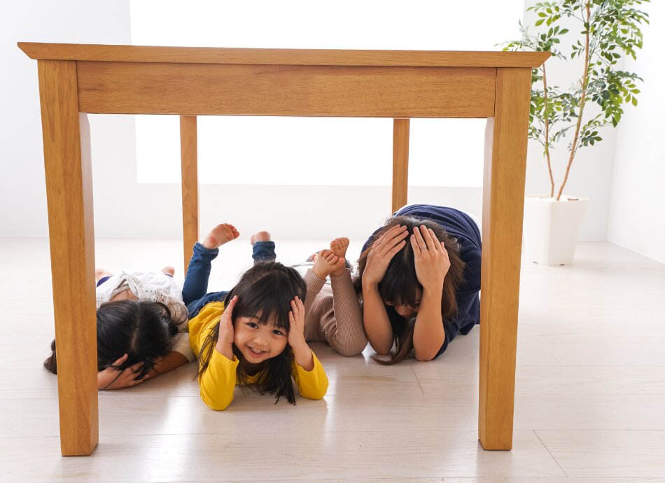 Family sheltering under table during earthquake 
