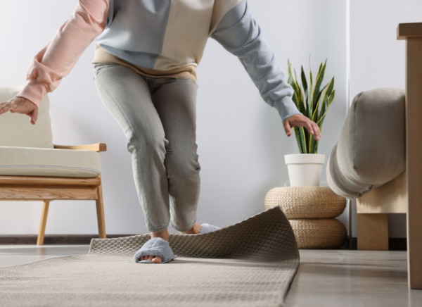 Woman tripping over a rug at home and about to fall