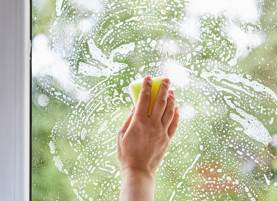 Woman's hand washing window 