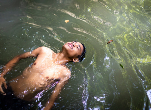 Boy swimming in waterway
